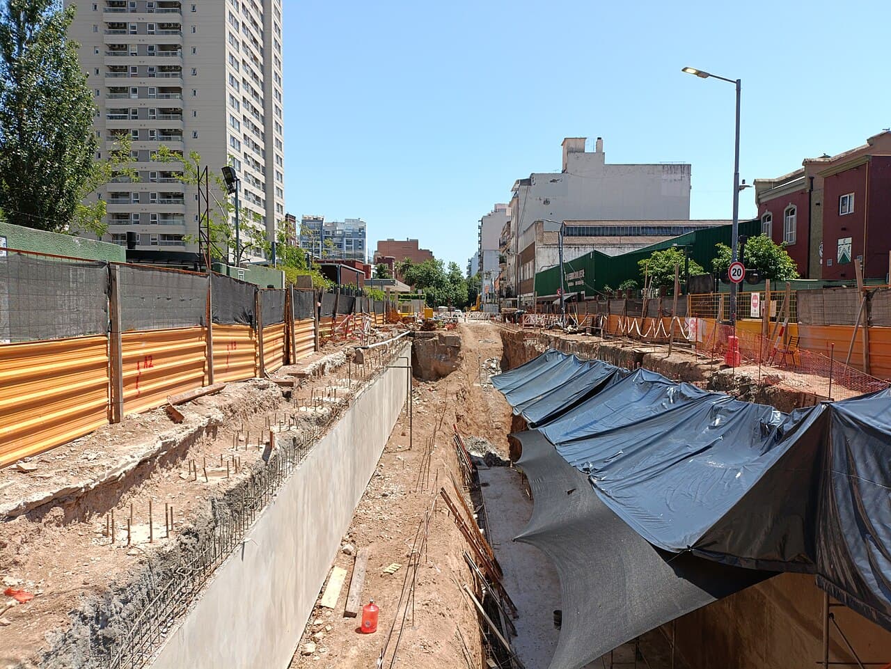 Vista de una estructura de edificio en obra con andamios y materiales apilados.